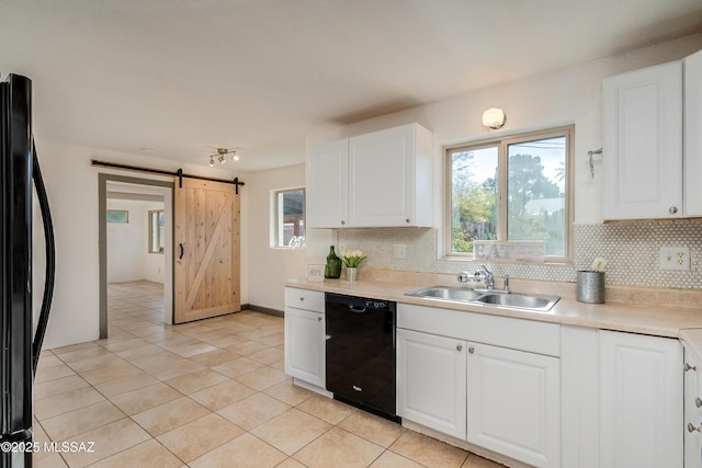 kitchen featuring black appliances, white cabinets, a barn door, and sink