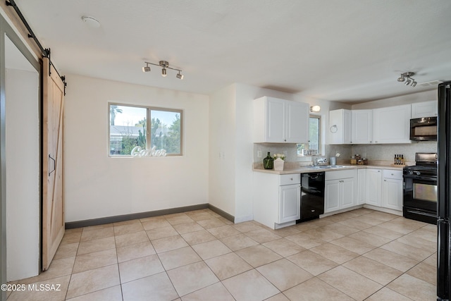 kitchen featuring black appliances, tasteful backsplash, a barn door, white cabinetry, and sink