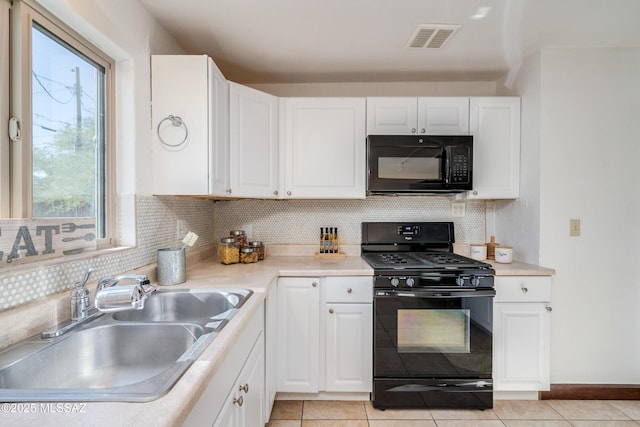 kitchen with black appliances, light tile patterned floors, decorative backsplash, sink, and white cabinetry