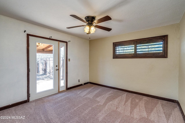 carpeted empty room featuring ceiling fan