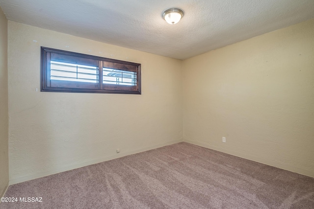 empty room with a textured ceiling and carpet flooring