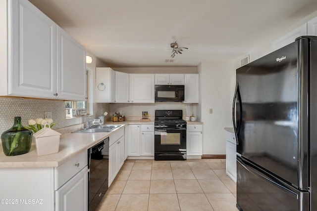 kitchen featuring sink, white cabinets, tasteful backsplash, and black appliances