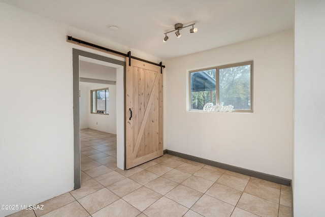 empty room with a barn door and rail lighting