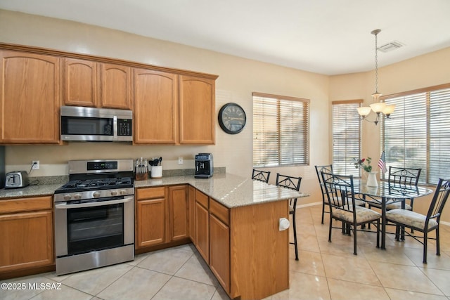 kitchen featuring an inviting chandelier, stainless steel appliances, light tile patterned flooring, decorative light fixtures, and kitchen peninsula