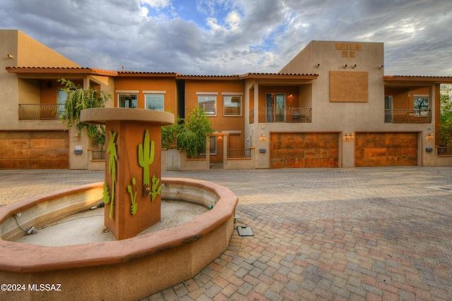 view of front of house featuring a garage and a balcony