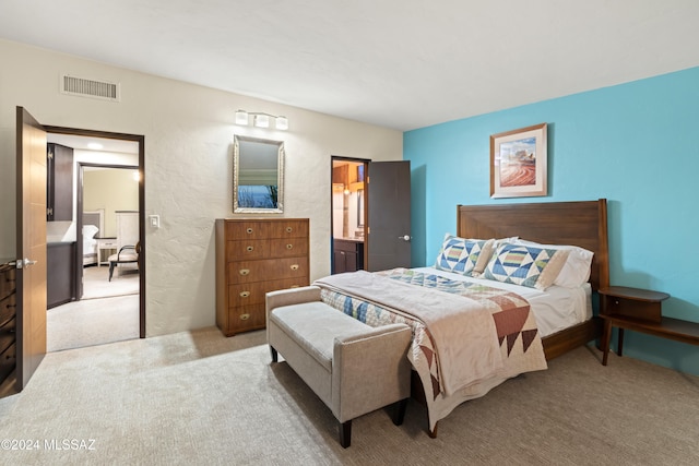 bedroom with light carpet and ensuite bathroom