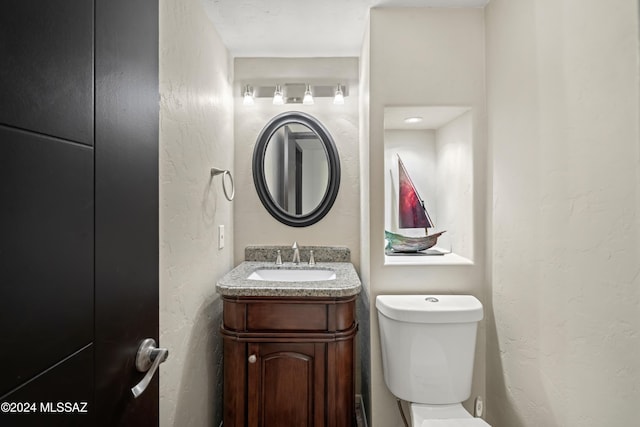 4750 N Calle Desecada, Tucson, AZ 85718 - half bathroom featuring toilet, vanity, and a textured wall
