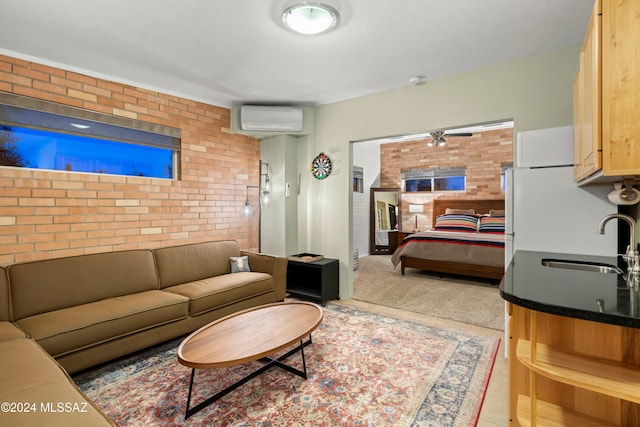 living room with ceiling fan, sink, a wall mounted AC, and brick wall