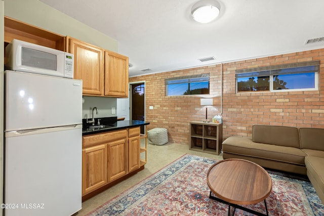 living room featuring sink and brick wall