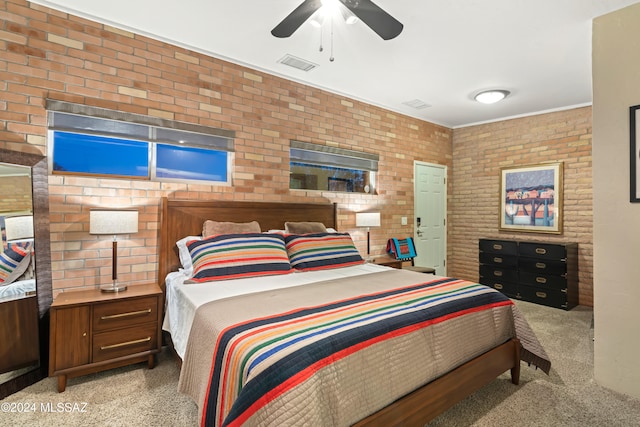 bedroom with ceiling fan, light colored carpet, and brick wall