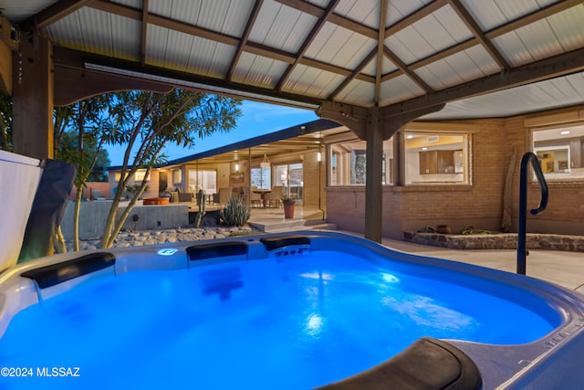 pool at dusk featuring a patio