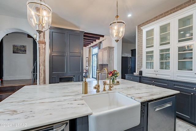 kitchen featuring a sink, light stone counters, dishwasher, and glass insert cabinets