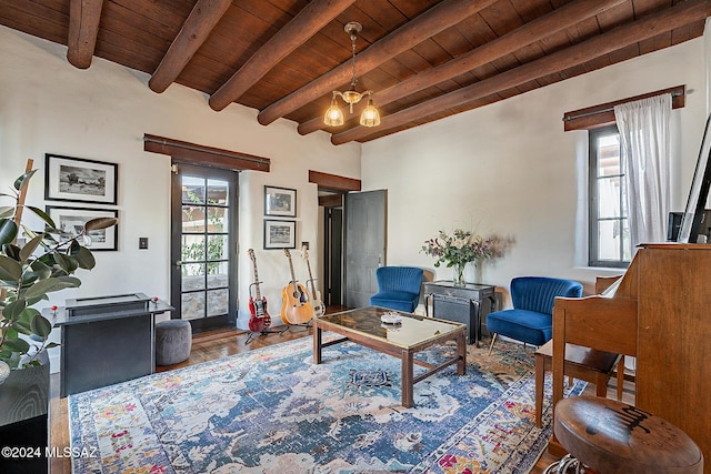 sitting room with an inviting chandelier, wooden ceiling, and beamed ceiling