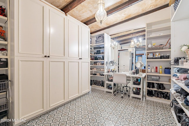 home office with a notable chandelier and beamed ceiling