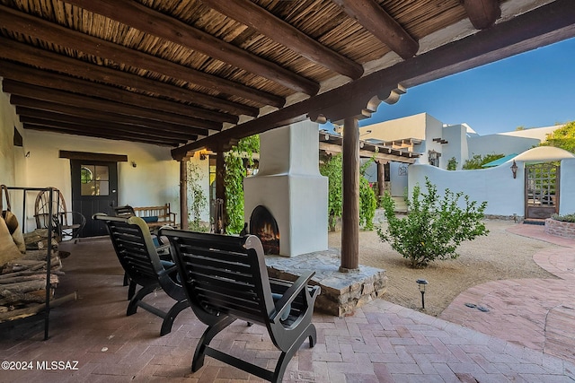 view of patio / terrace with outdoor dining space and a lit fireplace