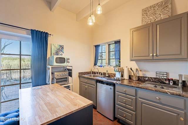 kitchen with beamed ceiling, white microwave, a sink, dishwasher, and gray cabinetry