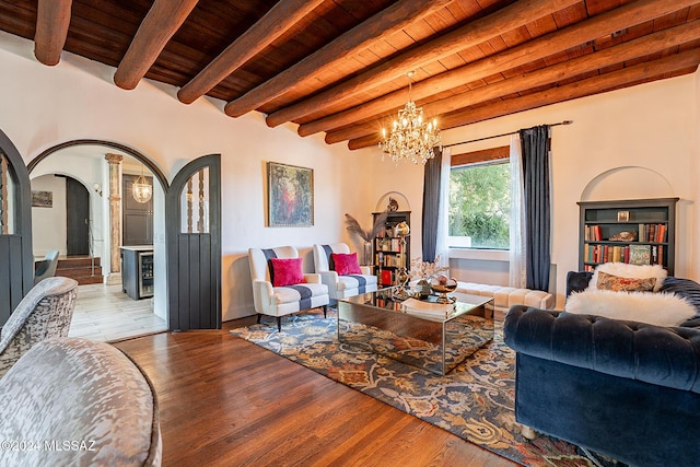 living area featuring wooden ceiling, beamed ceiling, arched walkways, and a chandelier