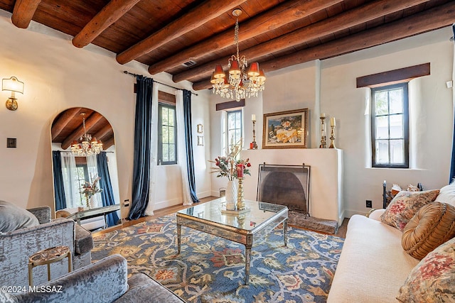 living room featuring wood ceiling, plenty of natural light, beamed ceiling, and a notable chandelier