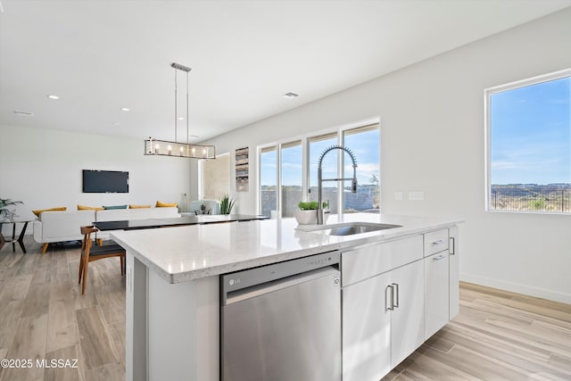 kitchen with a kitchen island with sink, a sink, white cabinets, hanging light fixtures, and dishwasher