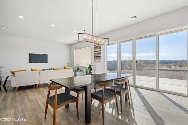 dining space with light wood finished floors, visible vents, and recessed lighting