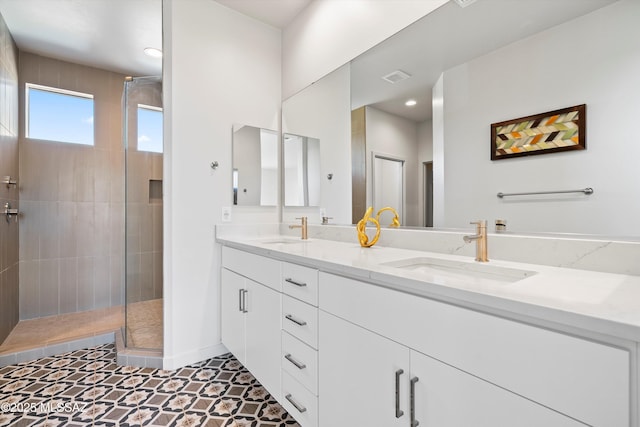 full bath featuring double vanity, a sink, visible vents, and a shower stall