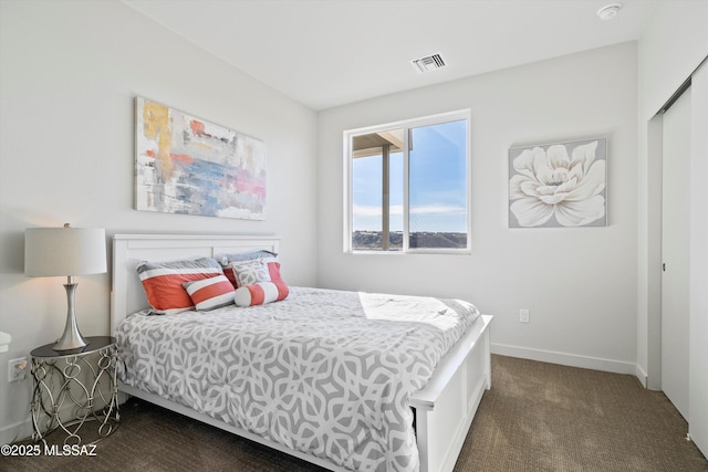 bedroom with visible vents, baseboards, and dark colored carpet