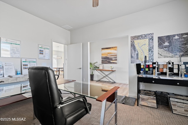 carpeted office space with visible vents and baseboards