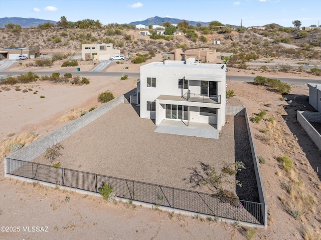 back of house featuring stucco siding, a fenced backyard, a mountain view, and a patio