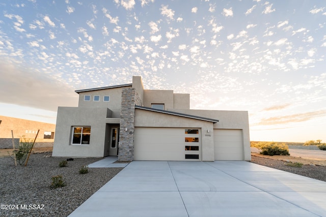 modern home with a garage, driveway, and stucco siding