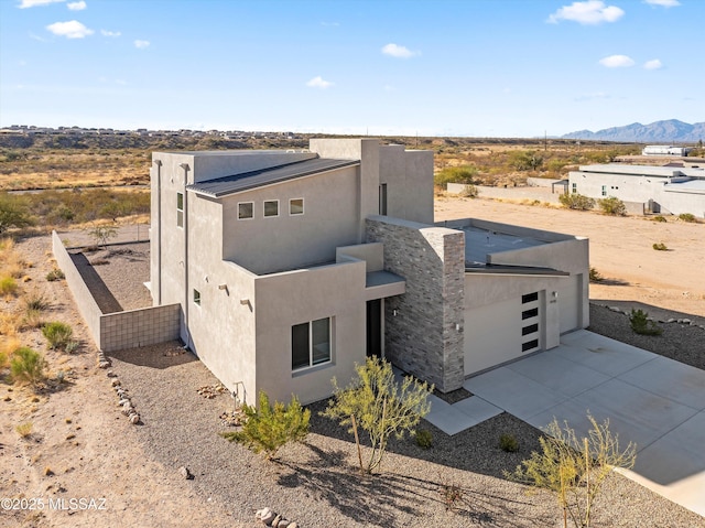 view of front of property featuring a mountain view, driveway, and stucco siding