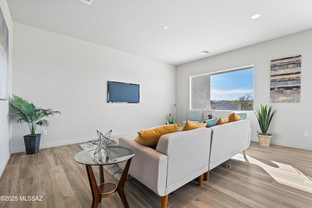 living area featuring light wood-style floors, recessed lighting, and baseboards