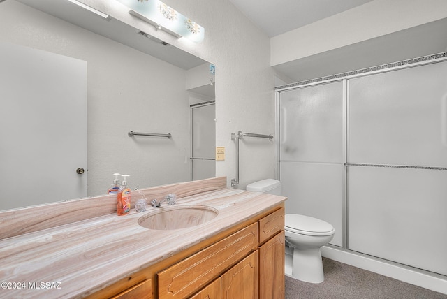 bathroom featuring vanity, toilet, and a shower with shower door