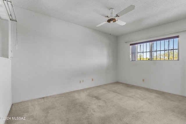 unfurnished room featuring light carpet, a textured ceiling, and ceiling fan