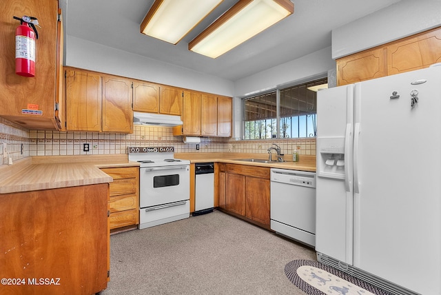 kitchen featuring white appliances, decorative backsplash, and sink