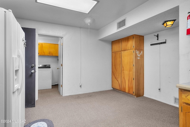 unfurnished bedroom featuring light carpet, white fridge with ice dispenser, and washer / clothes dryer