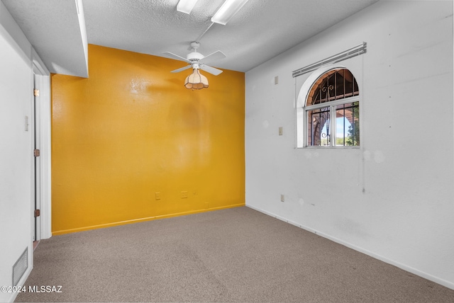 carpeted spare room featuring a textured ceiling and ceiling fan