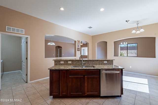 kitchen with a center island with sink, sink, and hanging light fixtures