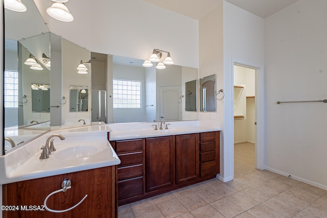 bathroom featuring vanity, a healthy amount of sunlight, a shower with shower door, and tile patterned flooring