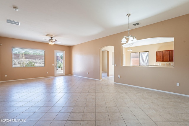 tiled spare room with sink and ceiling fan with notable chandelier