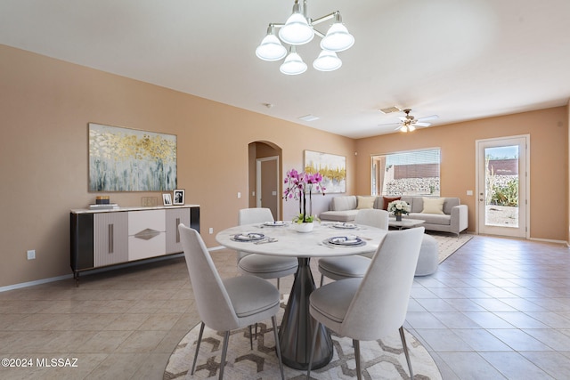 dining area featuring ceiling fan with notable chandelier and light tile patterned floors