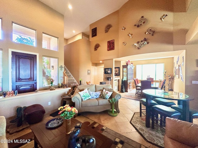 living room with light tile patterned floors and a high ceiling