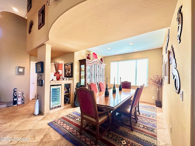 dining room featuring wine cooler and a textured ceiling