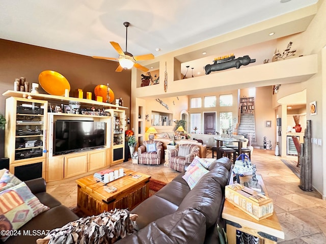 living room featuring ceiling fan and a high ceiling