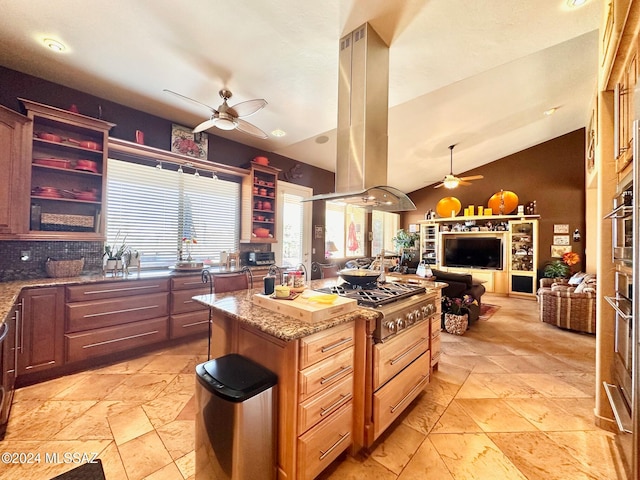 kitchen featuring island exhaust hood, light stone countertops, tasteful backsplash, a kitchen island, and lofted ceiling