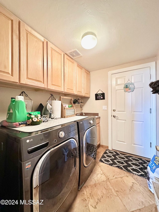 laundry area with washer and dryer, light tile patterned floors, and cabinets