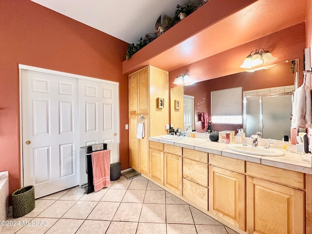 bathroom featuring tile patterned flooring, vanity, and a shower with shower door