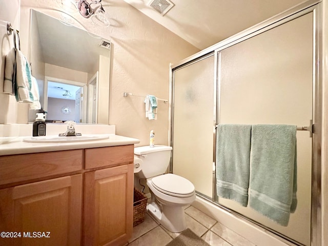 bathroom with tile patterned flooring, vanity, toilet, and an enclosed shower