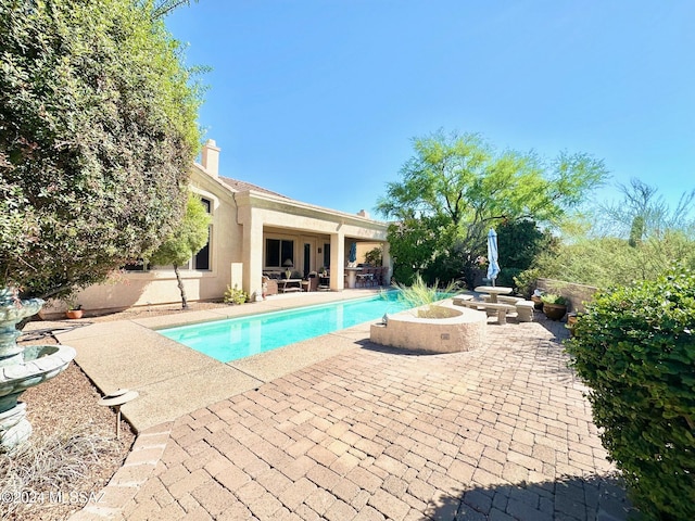 view of pool with a patio area and an outdoor fire pit