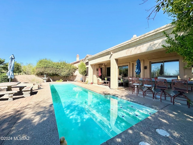 view of swimming pool with a patio and ceiling fan