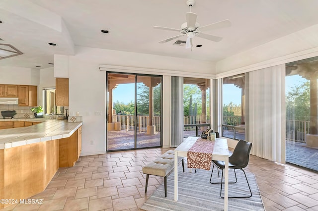 sunroom / solarium with ceiling fan and sink